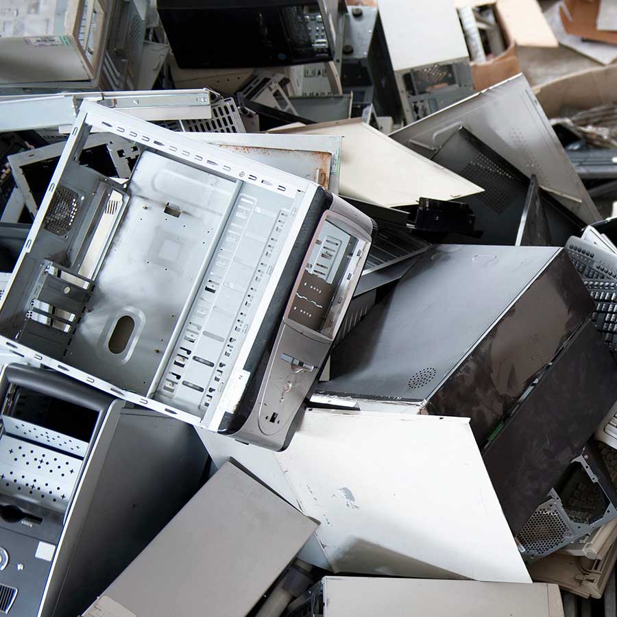 A pile of discarded computer cases and electronic components stacked haphazardly, suggesting electronic waste or a recycling center.